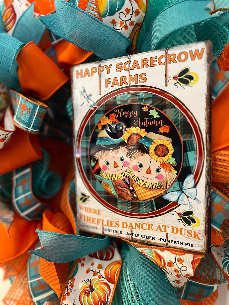 Autumn wreath for a homeowner. Teal and orange, with a large bow and metal sign. Festive and vibrant!