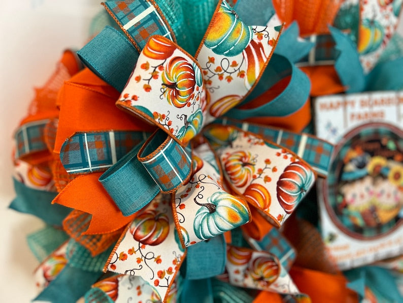 Autumn wreath for a homeowner. Teal and orange, with a large bow and metal sign. Festive and vibrant!